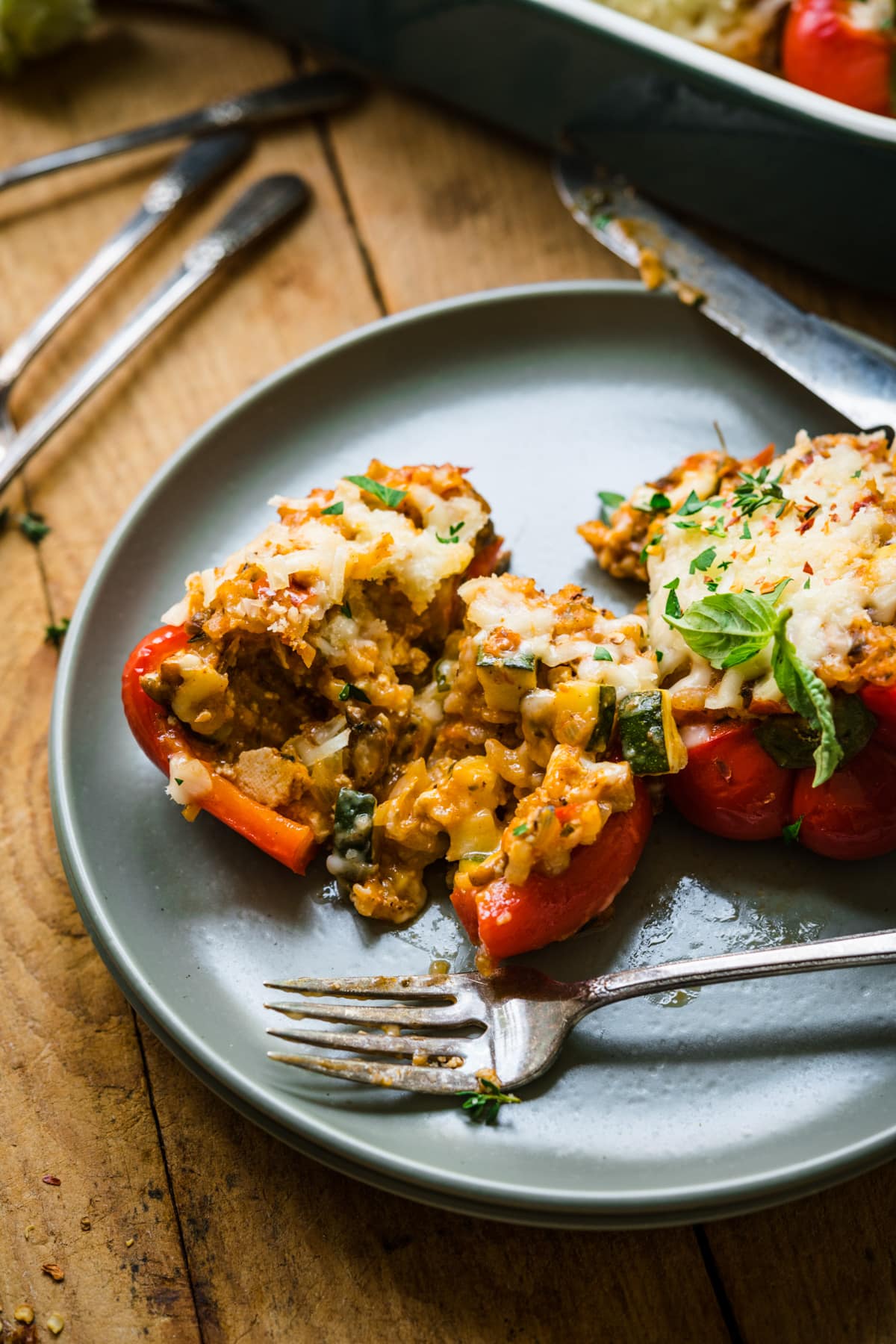 close up view of vegan stuffed pepper sliced in half on plate with fork. 