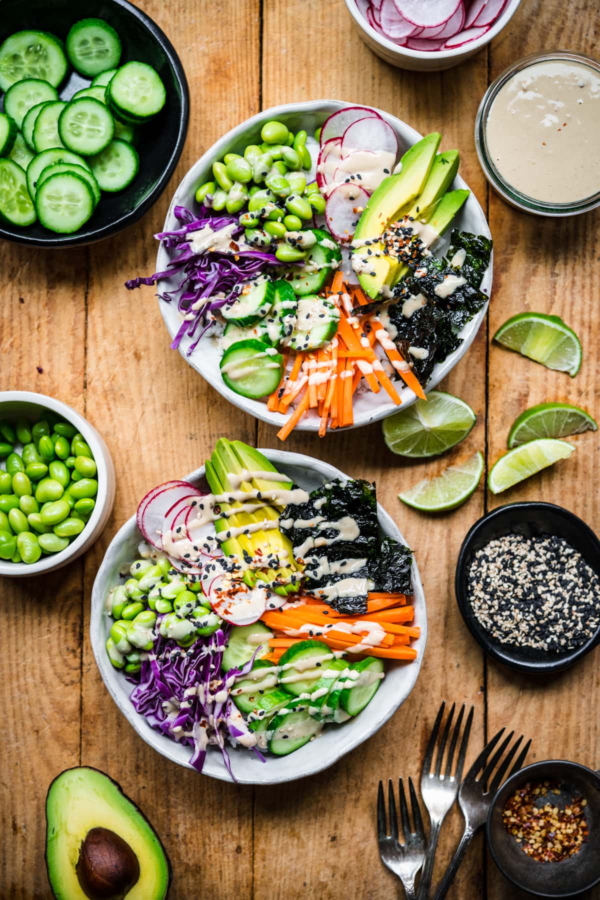 overhead view of vegan sushi bowls with avocado, radishes, cucumber, edamame and miso tahini dressing. 