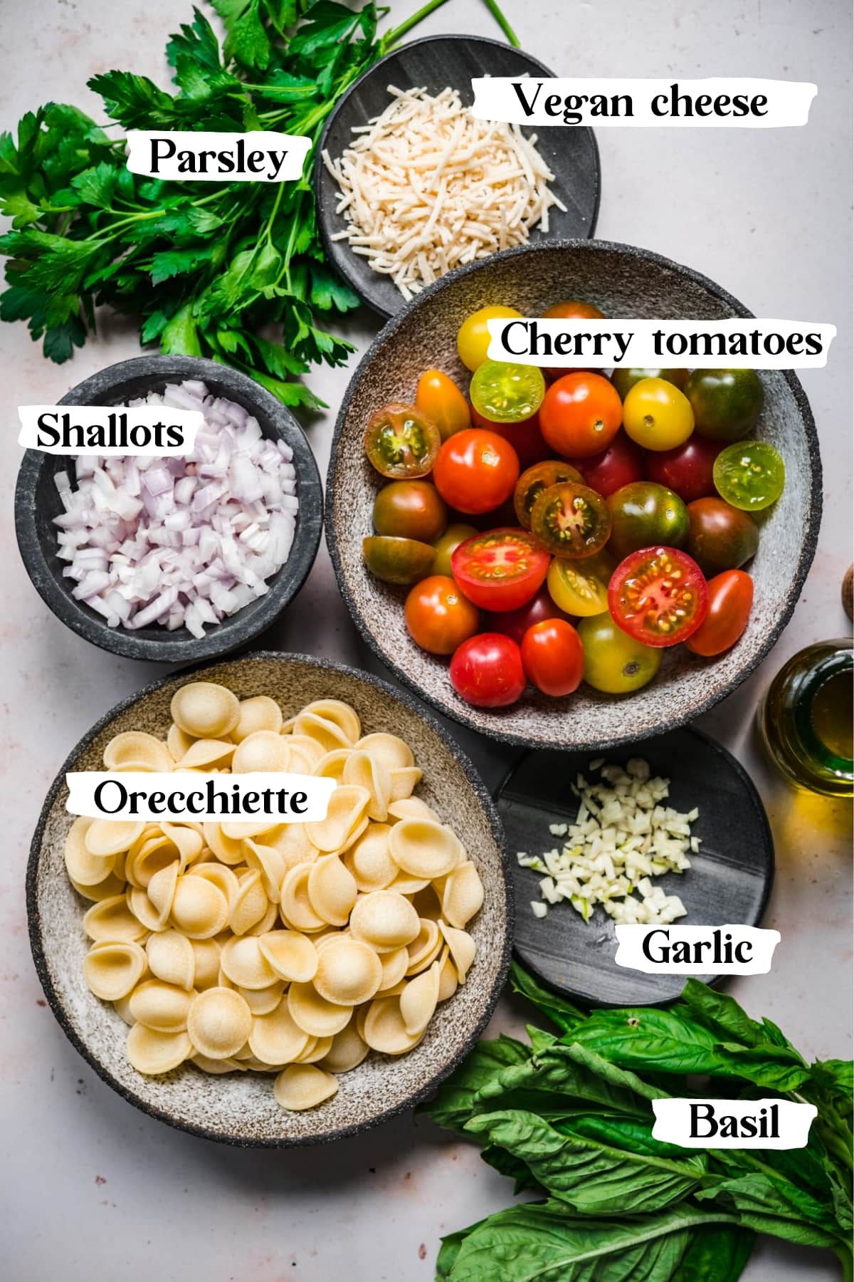 overhead view of ingredients for burst cherry tomato pasta in prep bowls. 