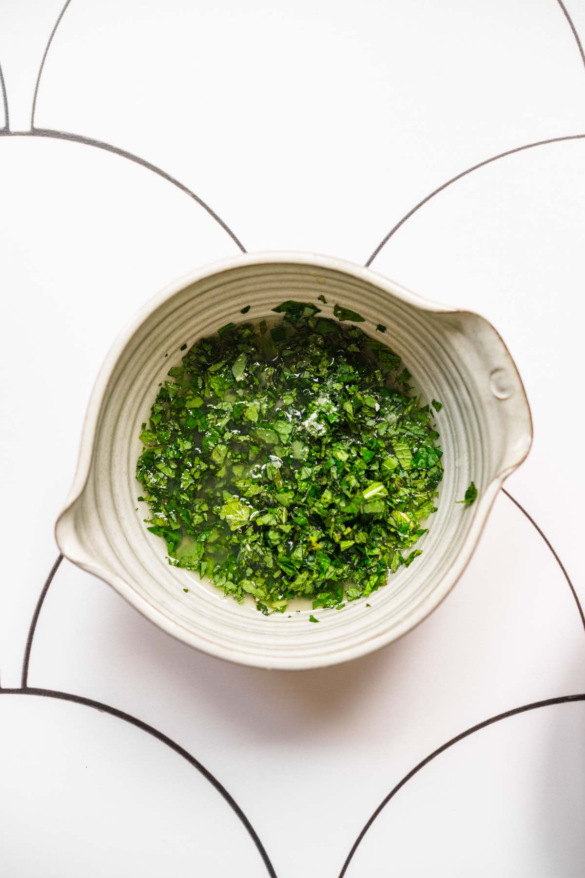 close up overhead view of lime mint dressing in white bowl. 