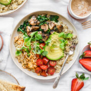 overhead view of vegan savory quinoa breakfast bowl with tofu, avocado and mushrooms.