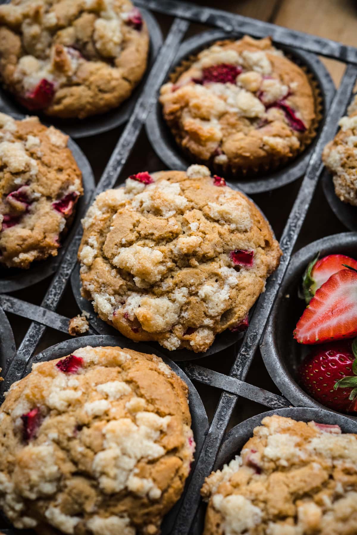 close up view of vegan strawberry muffins in tin with streusel on top. 