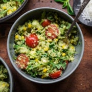 Green goddess salad in a bowl with a spoon. Full of quinoa and cherry tomatoes.