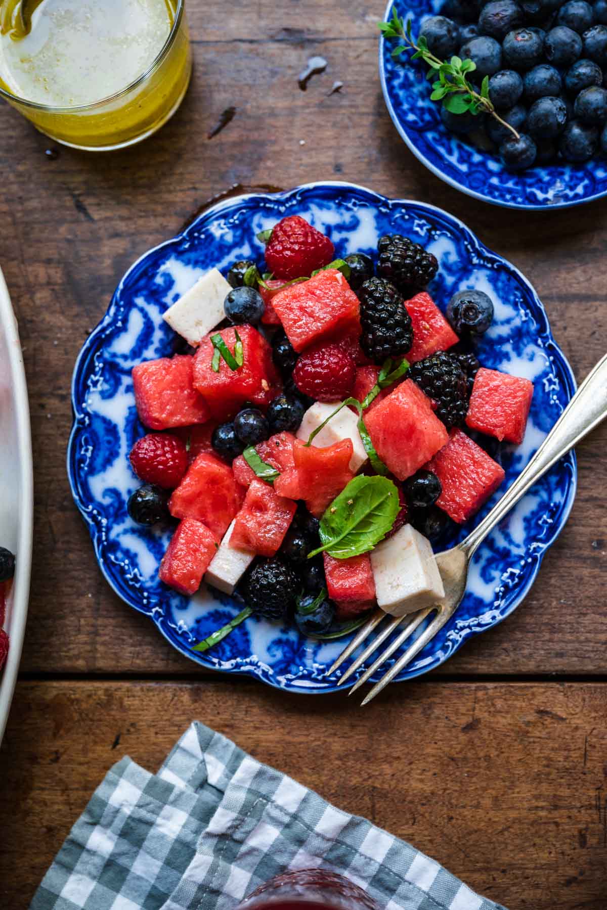 close up overhead view of red white and blue fruit salad on a blue plate. 