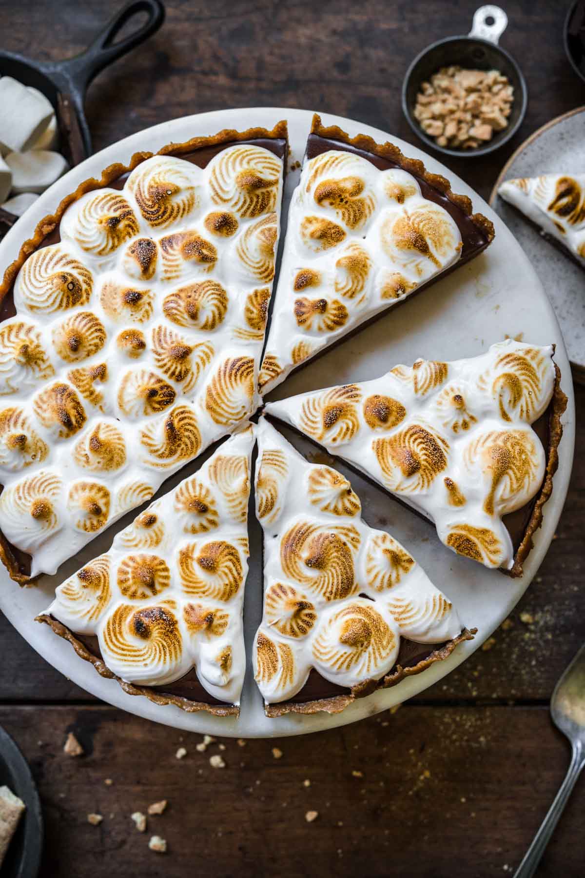 overhead view of sliced vegan s'mores tart on cake stand. 