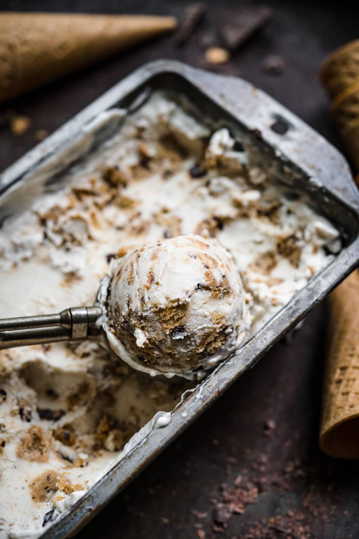 close up view of scoop of vegan cookie dough ice cream in ice cream tin.