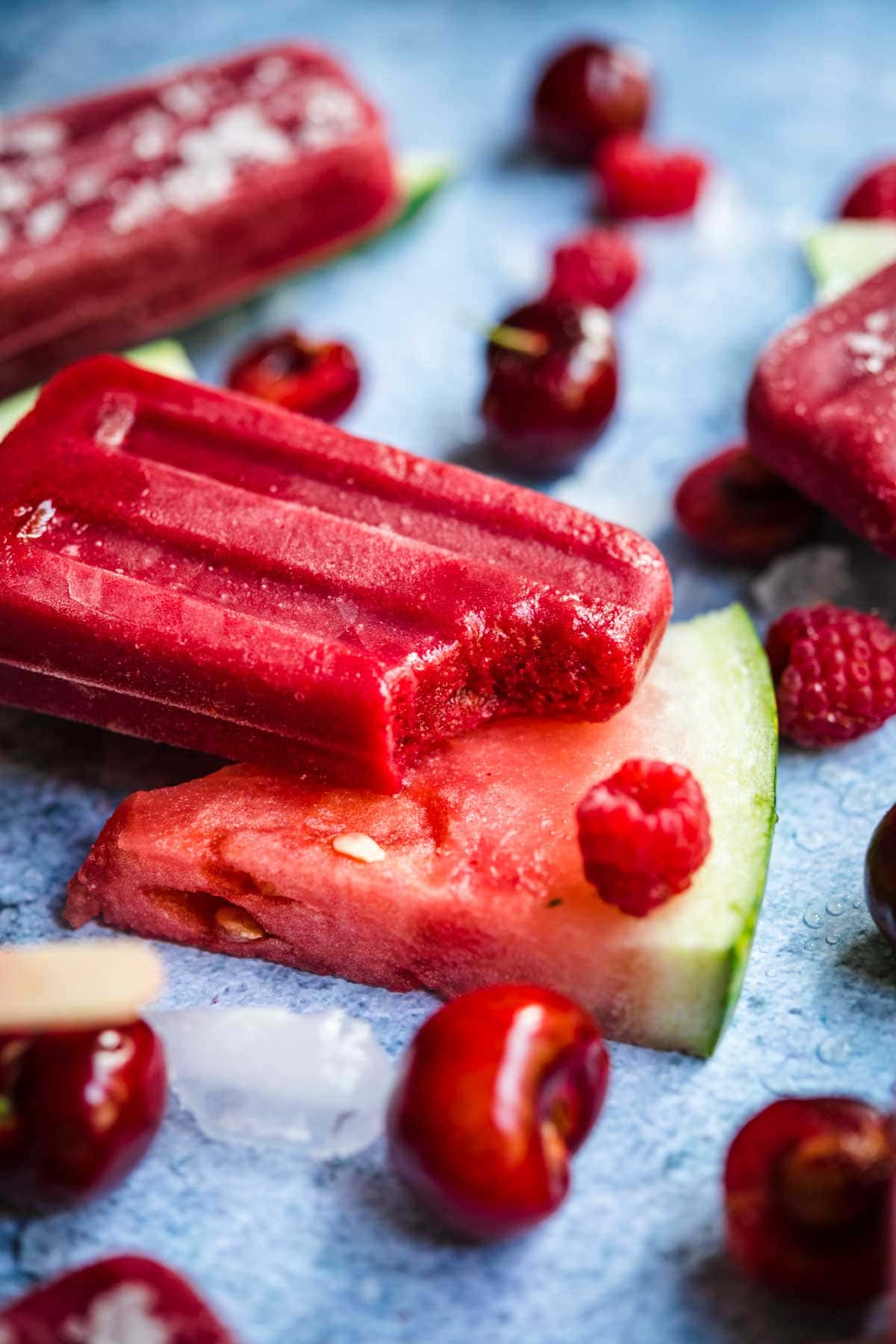 close up view of watermelon berry popsicle with bite taken out. 