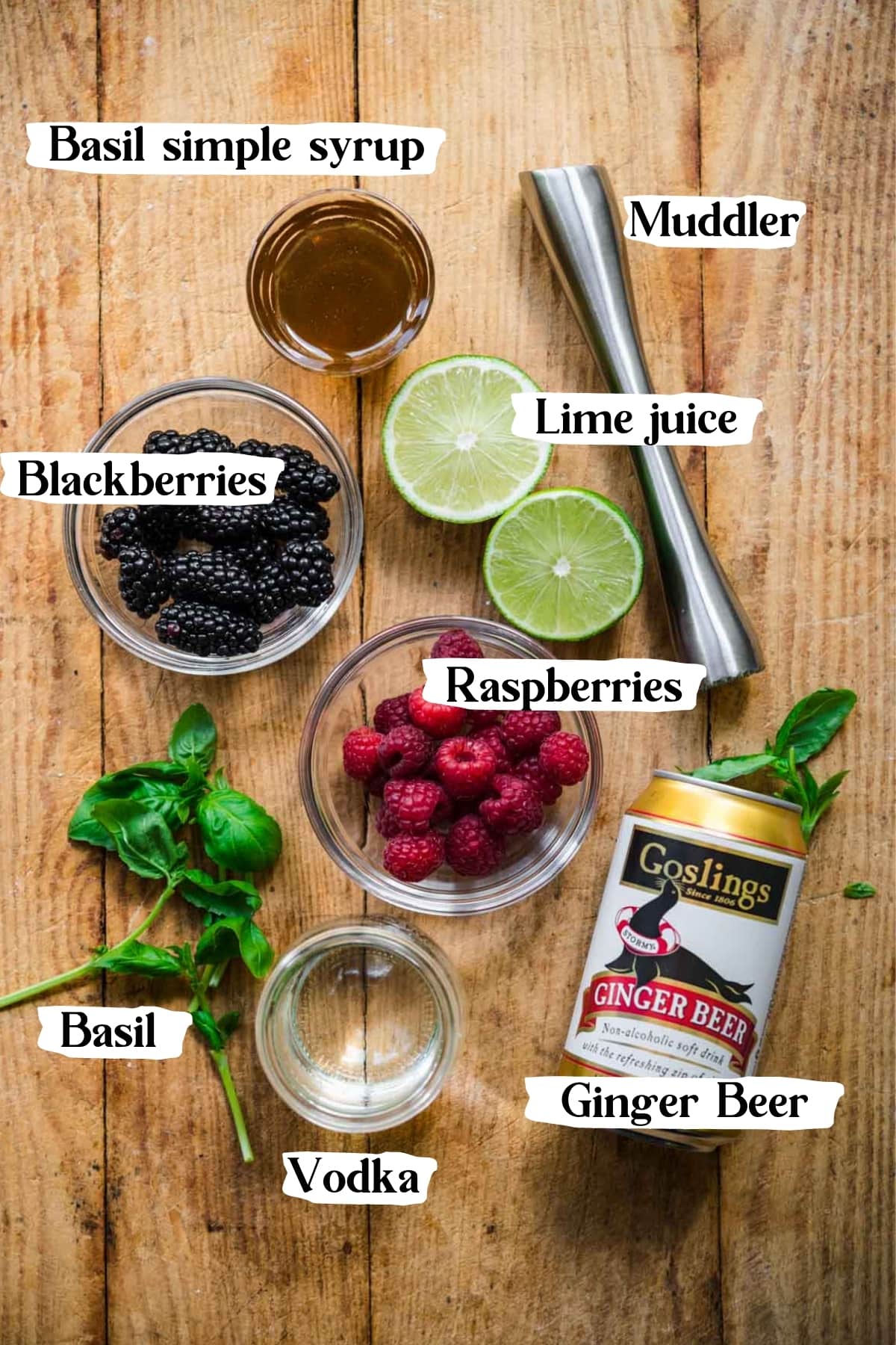 overhead view of ingredients for berry basil moscow mules on wood table. 