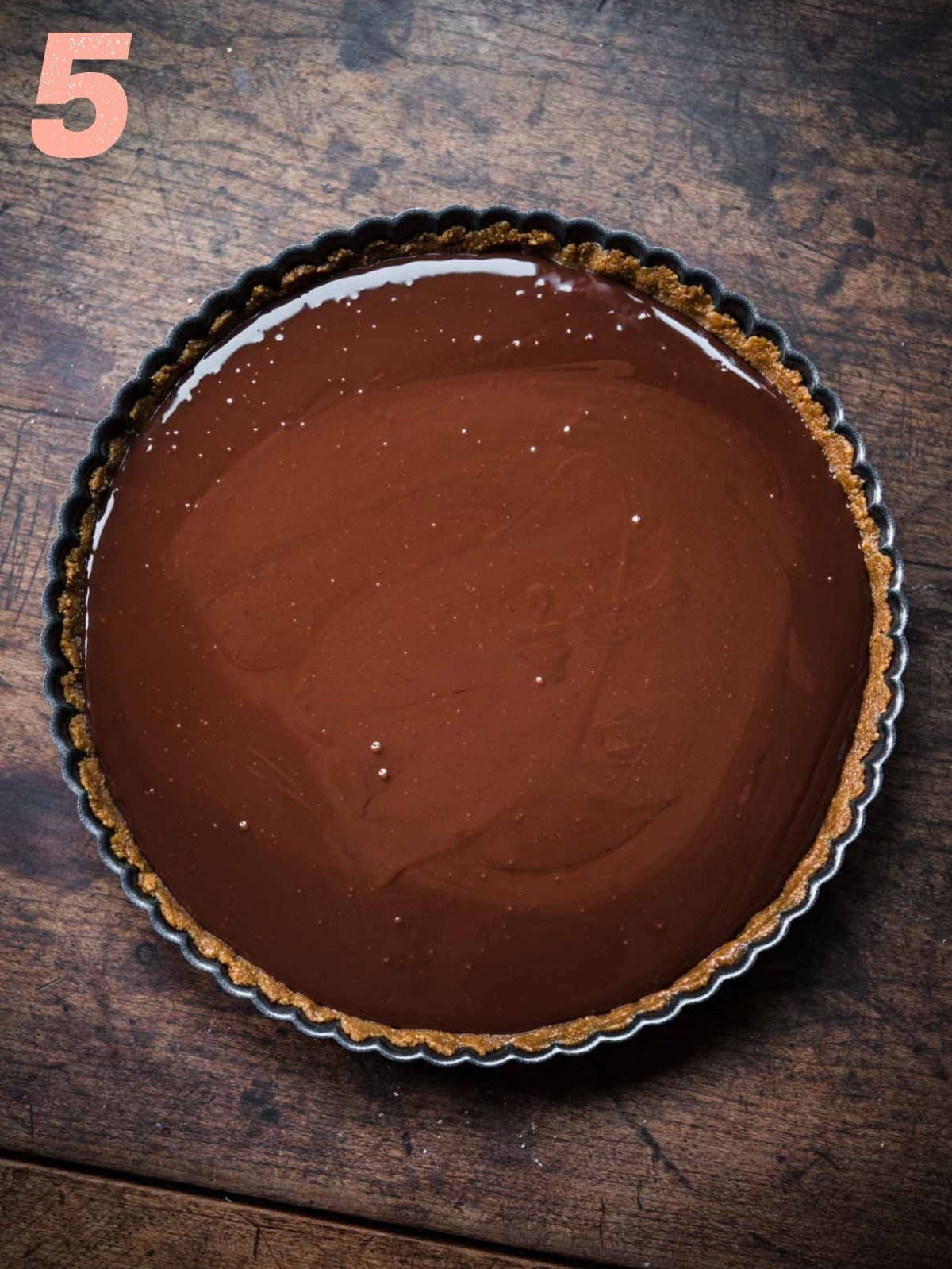 overhead view of chocolate ganache filling in graham cracker crust. 