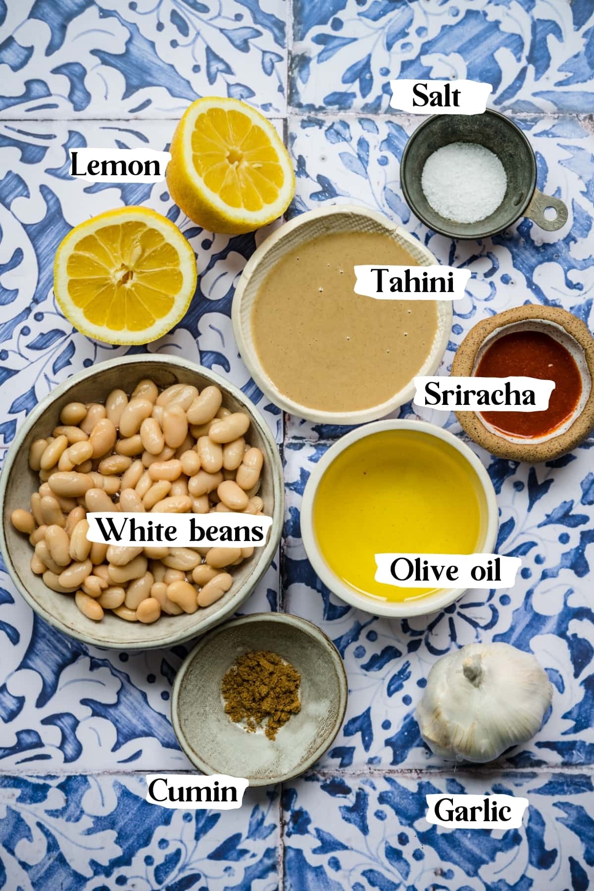 overhead view of ingredients for spicy white bean dip in small prep bowls. 