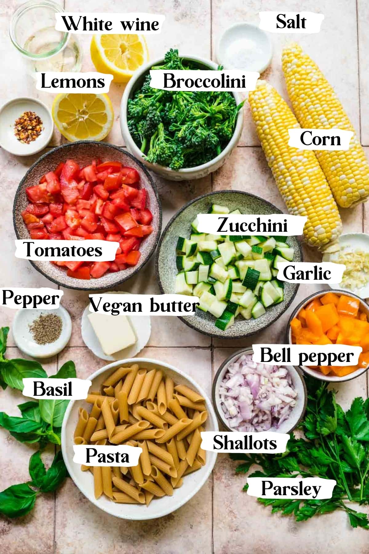 overhead view of ingredients for vegan summer vegetable pasta in small bowls. 