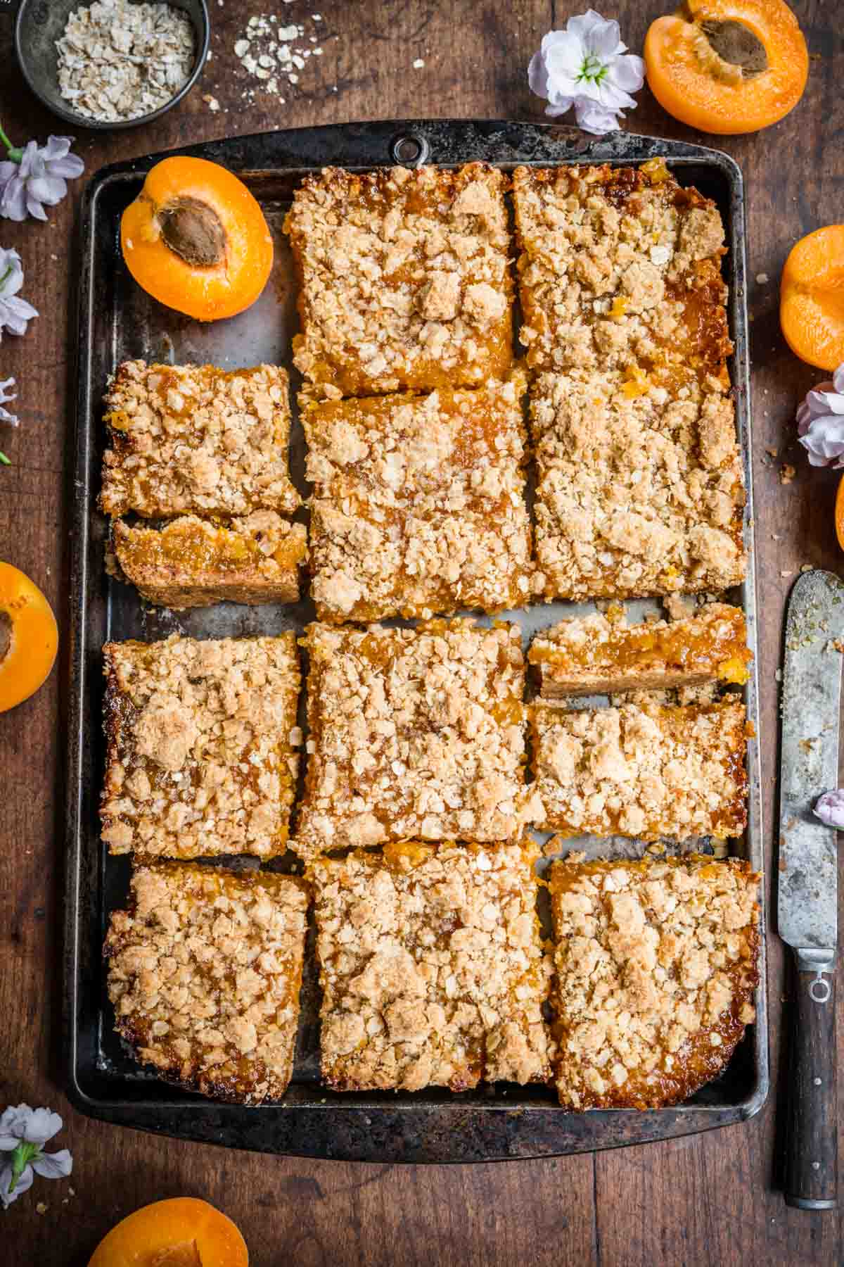 Fully baked apricot bars cut into squares set atop a tray.