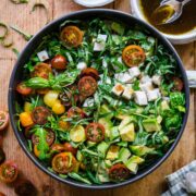 Overhead view of arugula caprese salad in a bowl.