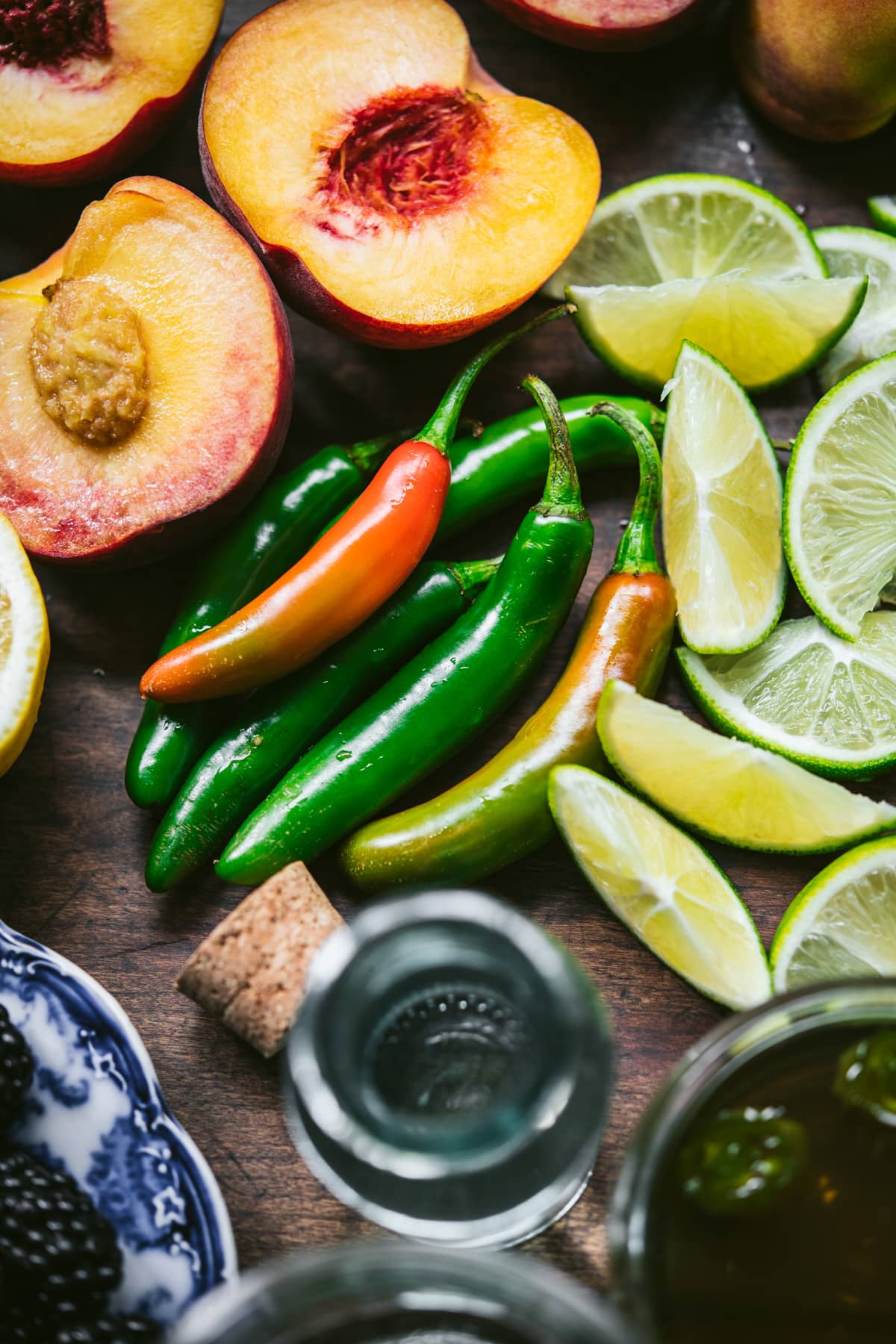 close up view of serrano peppers with limes and peaches. 