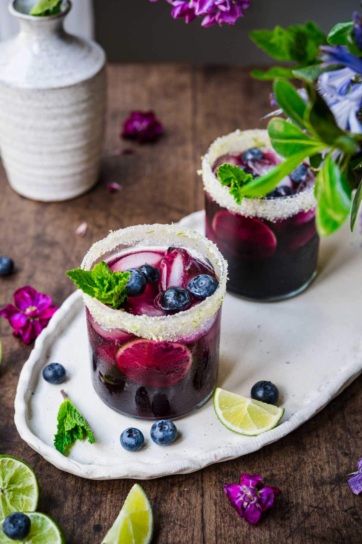 Overhead view of two blueberry margaritas sitting atop a tray.