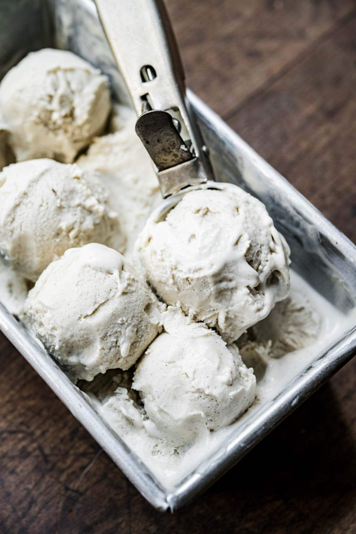 Tray of ice cream with a few balled scoops.