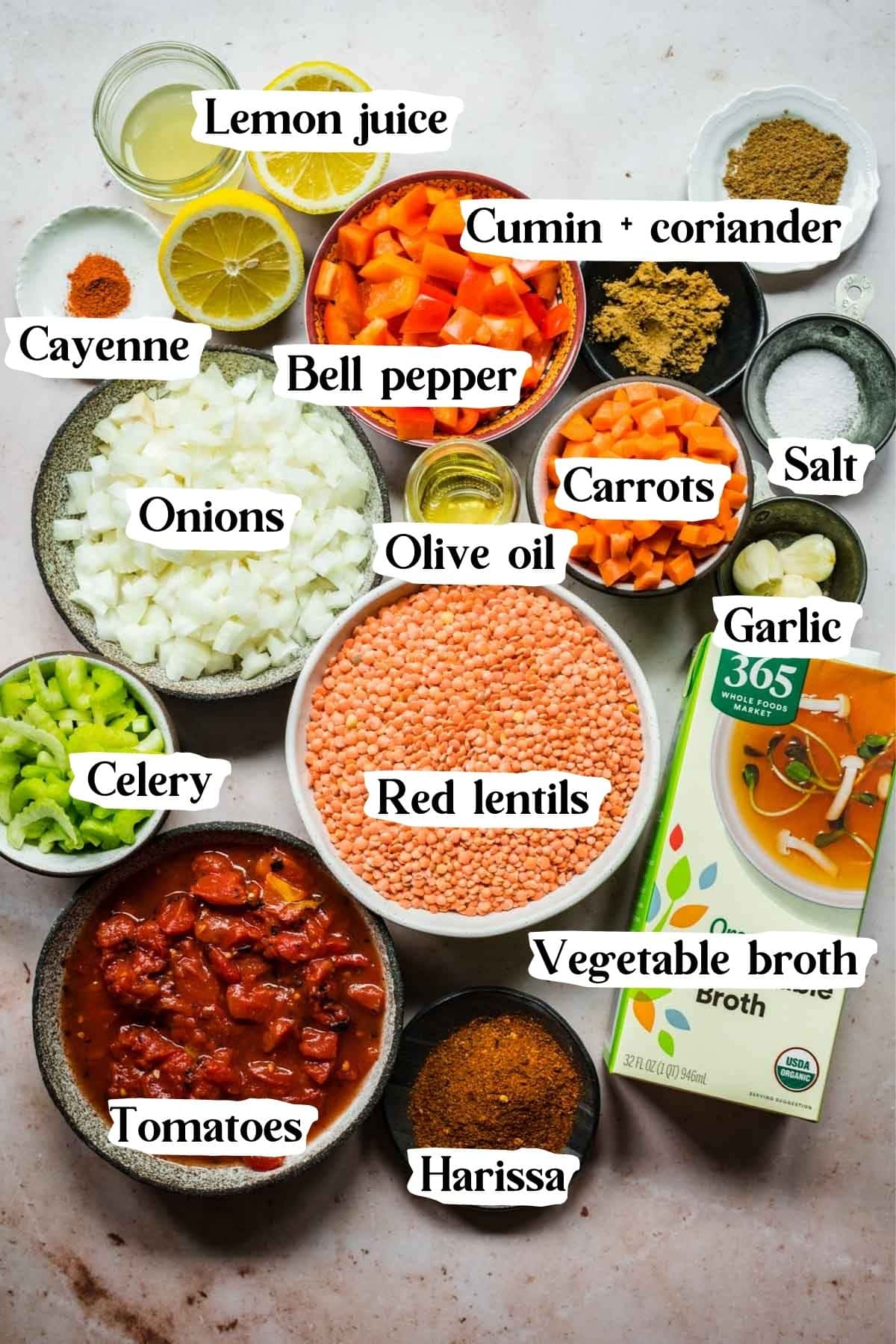 Overhead view of red lentil soup ingredients, including spices and vegetable broth.