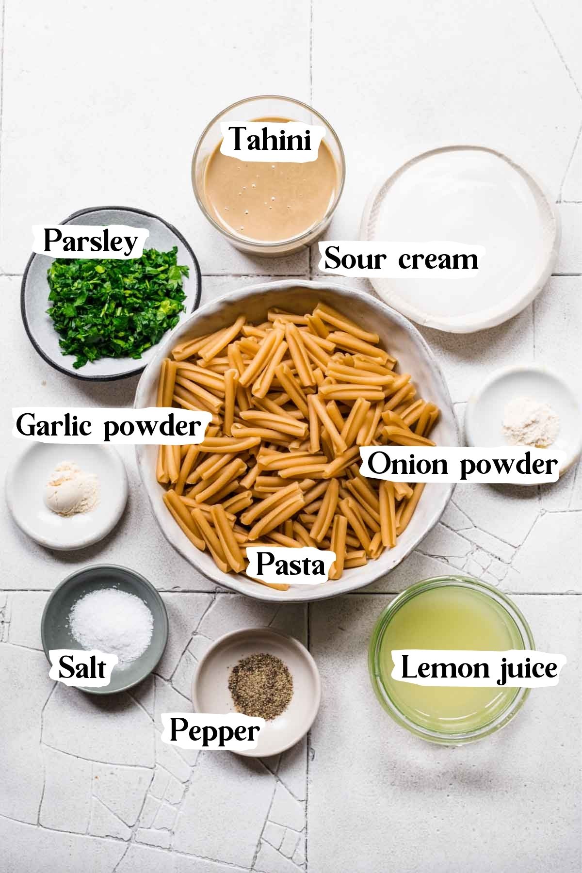 Overhead view of ingredients used in the tahini pasta, including tahini, parsley, and lemon juice.