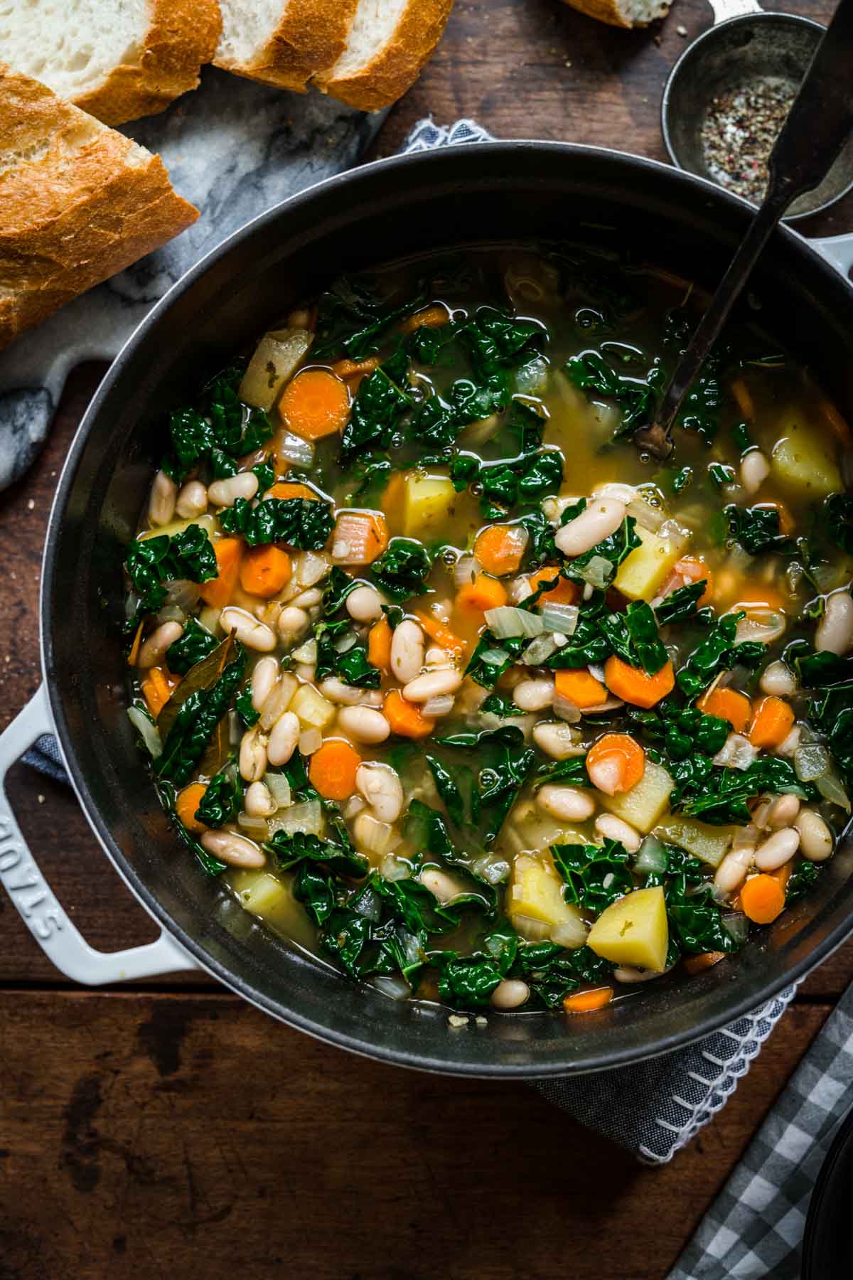 Overhead view of a big pot of white bean and kale soup.