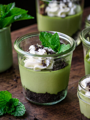 Front view of mini green cheesecake in a glass jar.