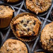 Banana walnut muffin in a muffin tin with a bite taken out.