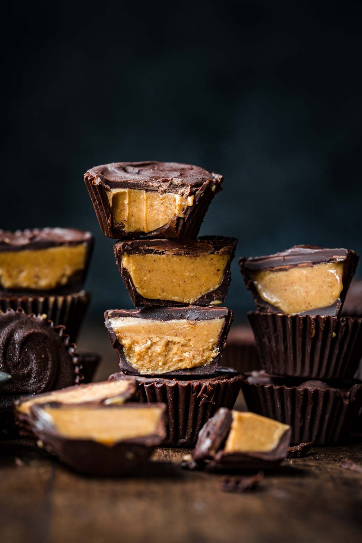 side view of a stack of homemade vegan peanut butter cups sliced in half. 