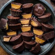 overhead view of vegan peanut butter cups on tin tray with some sliced in half and some whole.