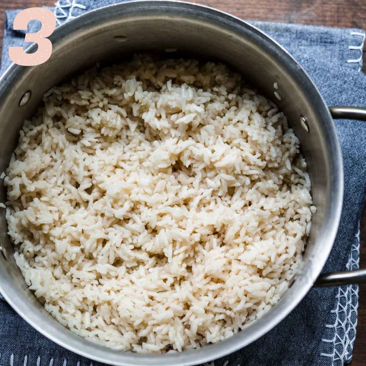 overhead view of white rice cooked in coconut milk in pot. 
