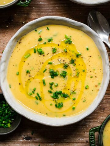 Overhead view of potato leek soup with herb garnish.