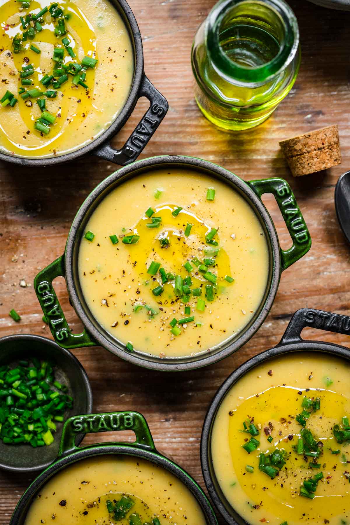 Overhead view of crocks full of potato leek soup with chives and pepper.