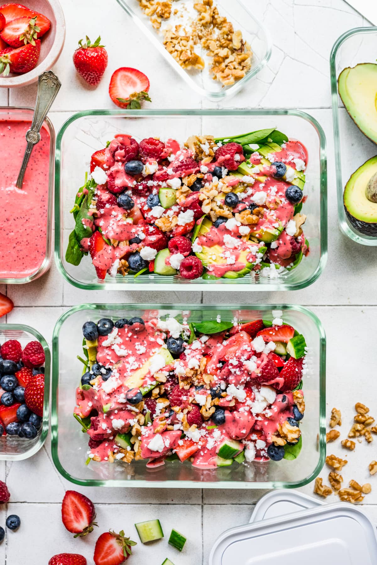 Overhead view of salad garnished with dressing, walnuts, and feta.