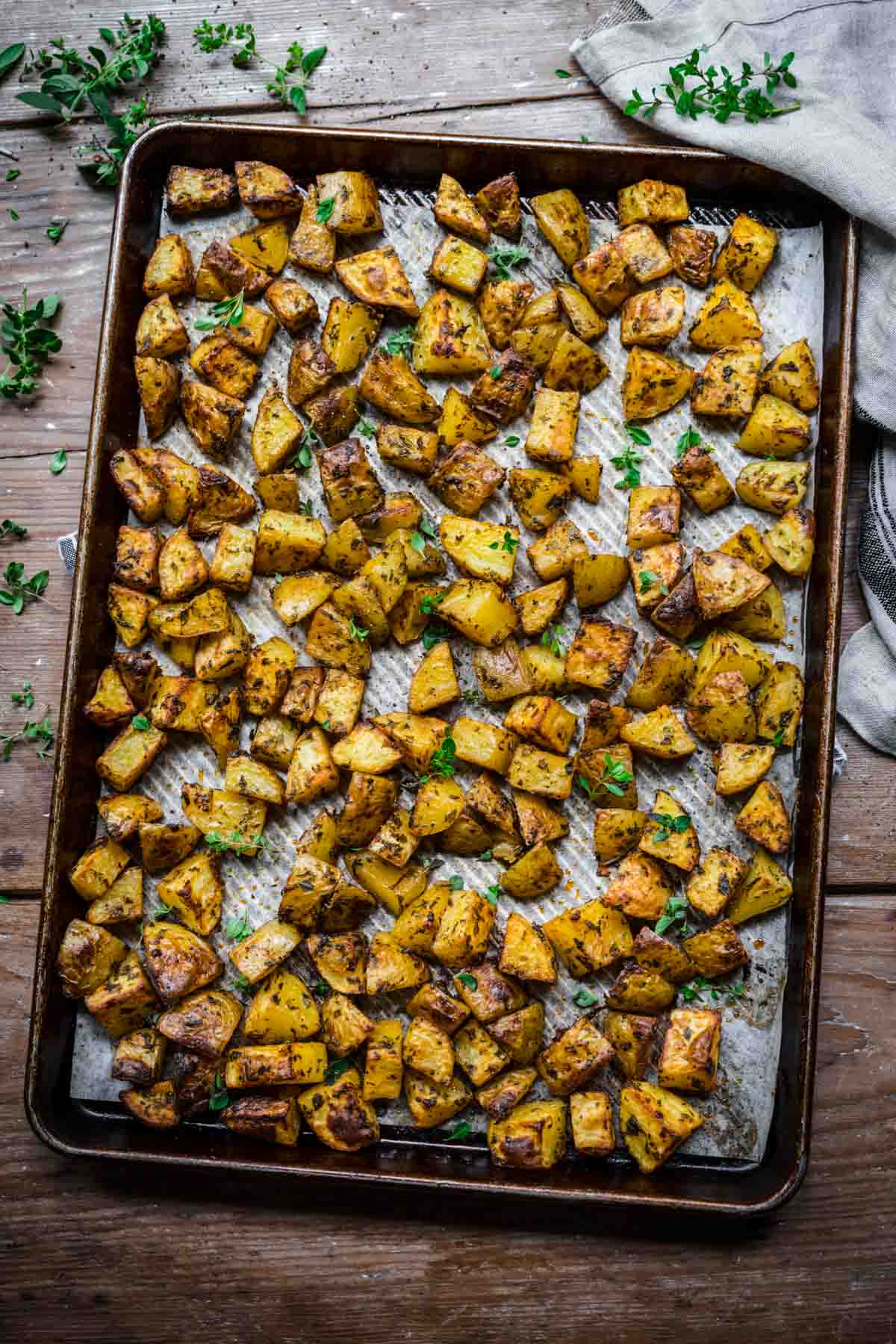 Herb roasted potatoes on a sheet pan.