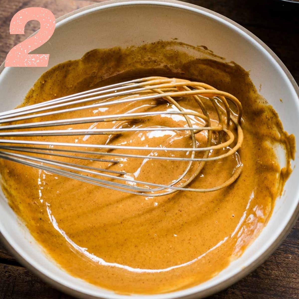 close up view of peanut butter filling in a mixing bowl with whisk.