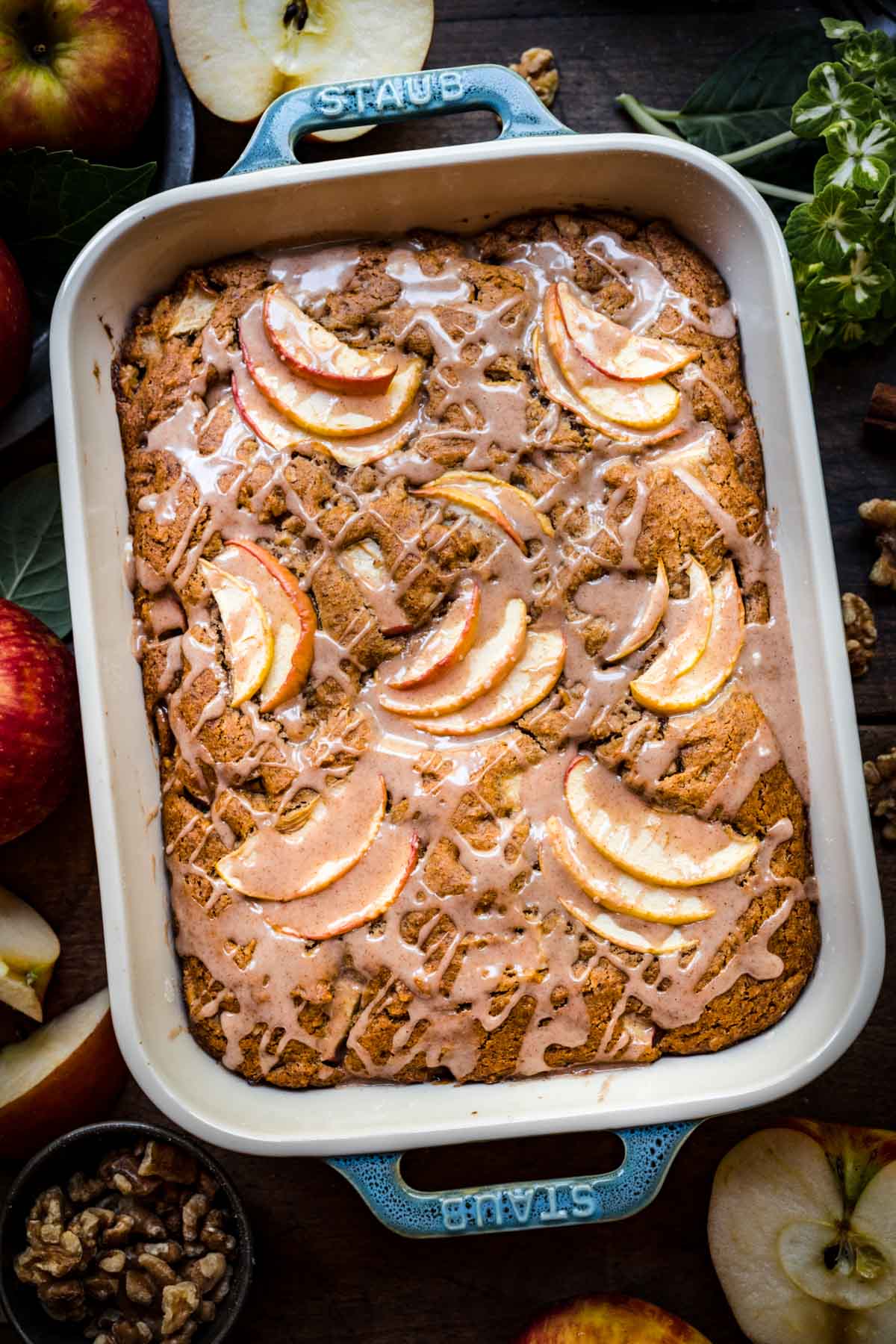 Overhead view of finished apple walnut cake with glaze in a baking dish.