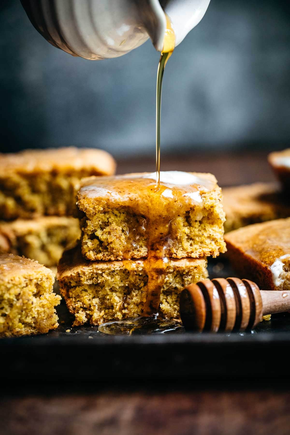 close up view of stack of gluten free vegan cornbread with drizzle of maple syrup. 