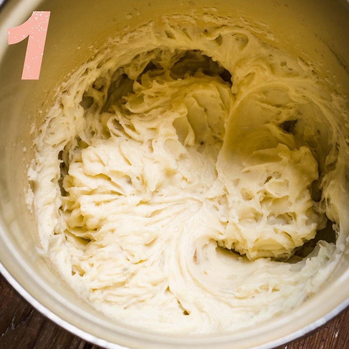 Overhead view of mashed potatoes being stirred together.