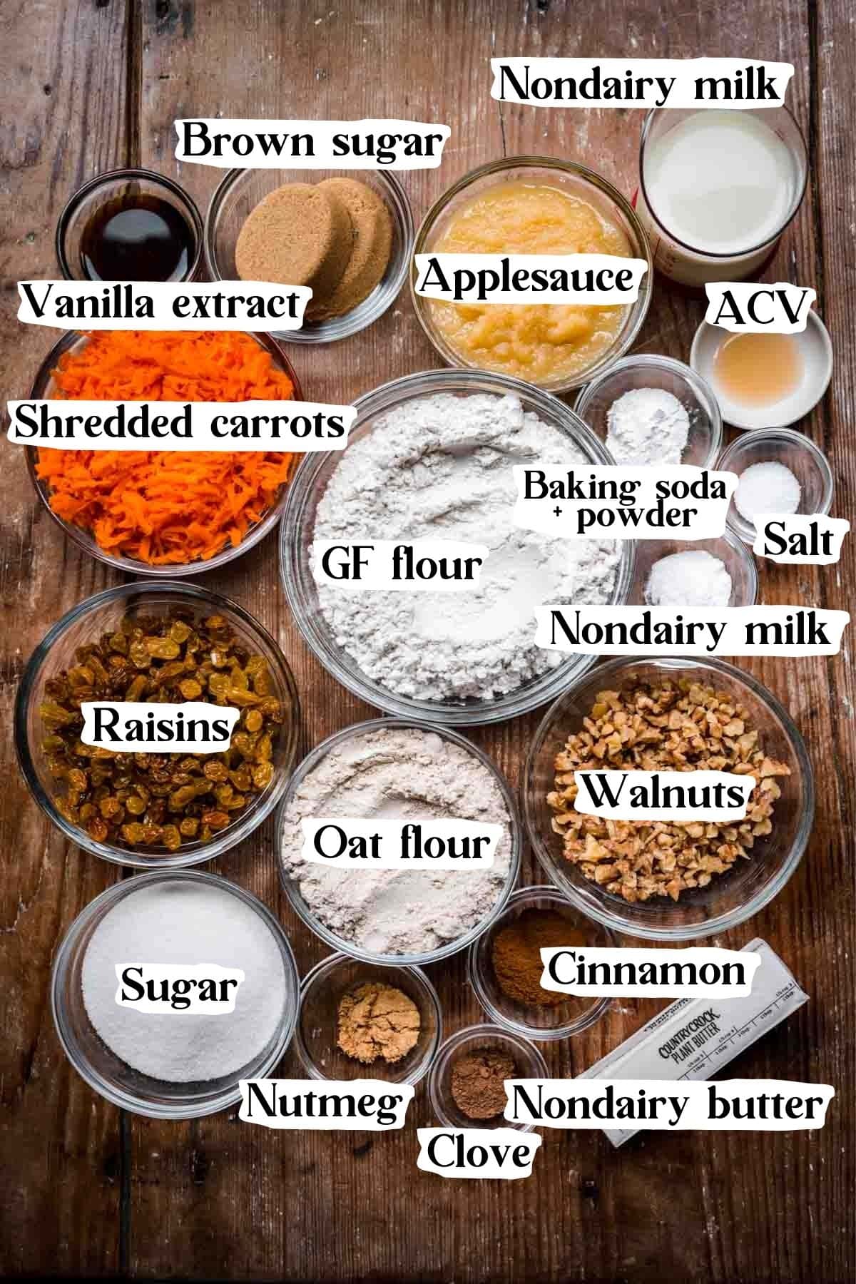 Overhead view of vegan carrot cake ingredients, including flour, sugar, carrots, and milk.