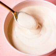 close up view of vegan sour cream in a bowl with spoon.