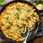 overhead view of vegan broccoli mac and cheese with crispy breadcrumb topping in large skillet.