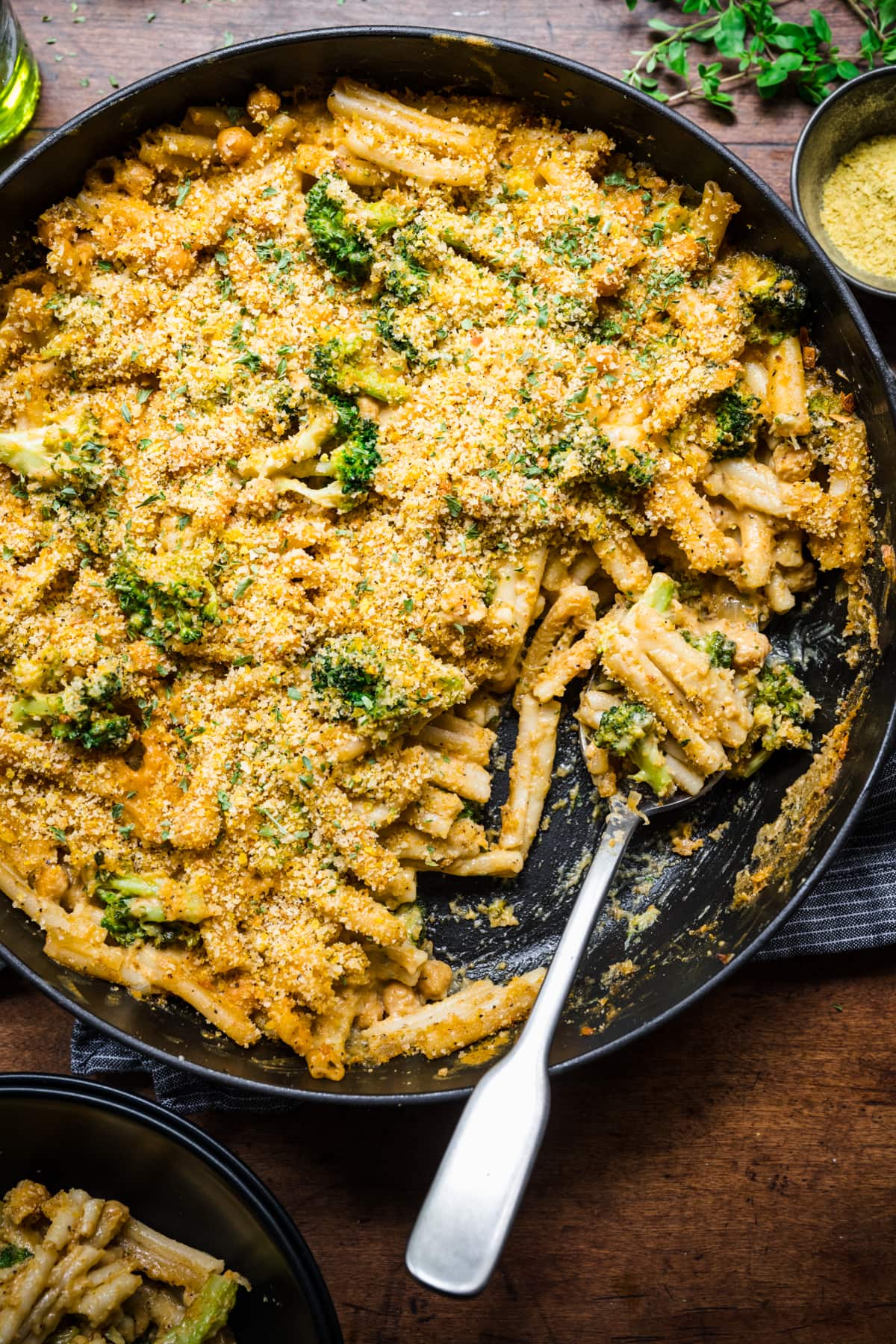 overhead view of vegan broccoli mac and cheese with crispy breadcrumb topping in large skillet.