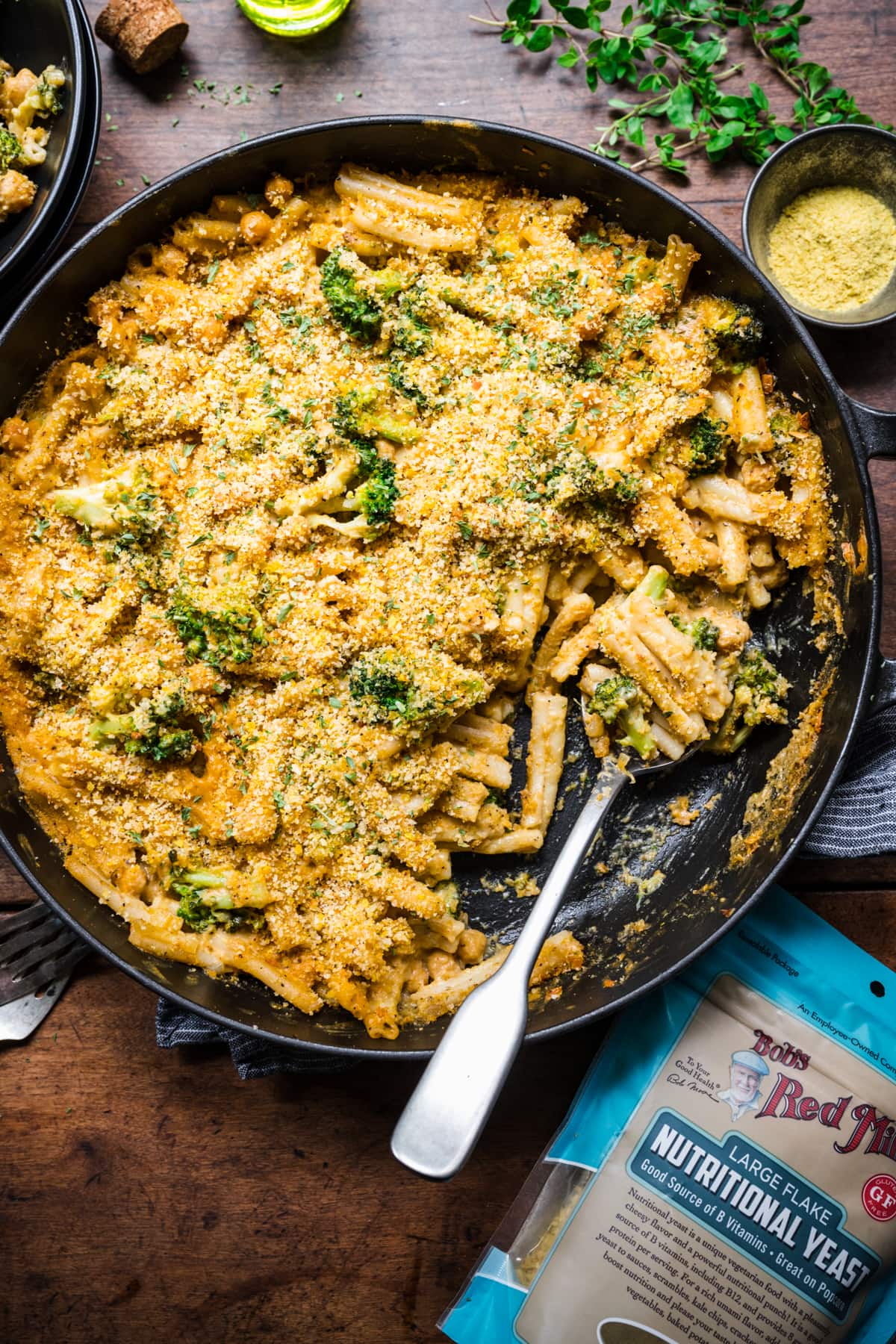 overhead view of vegan broccoli mac and cheese with crispy breadcrumb topping in large skillet.