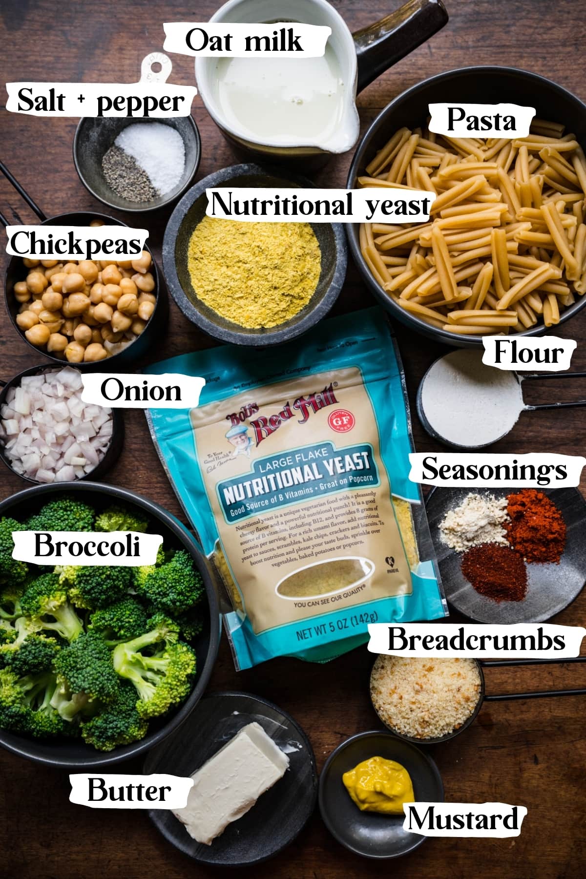 overhead view of ingredients for vegan broccoli mac and cheese on wood table. 