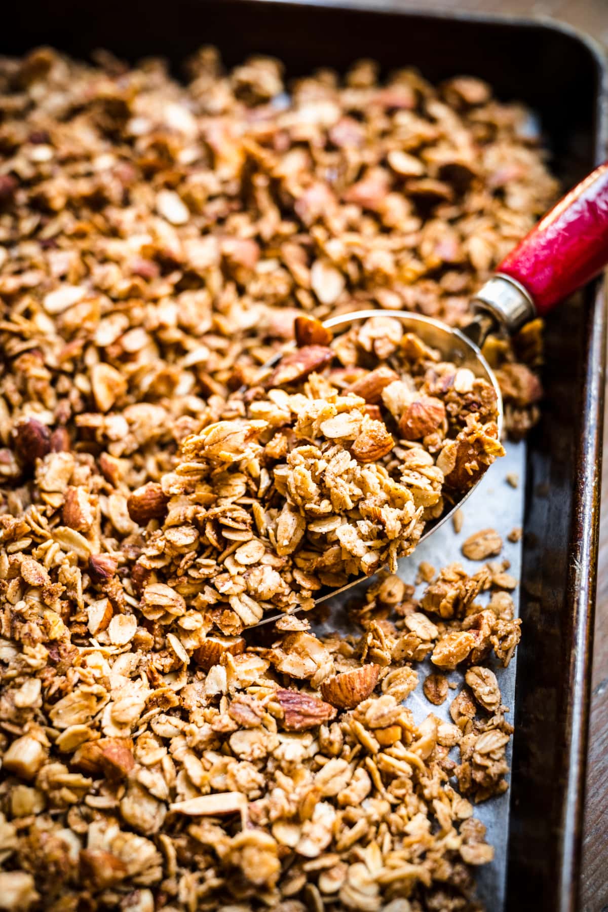 close up view of brown sugar almond granola on a sheet pan. 