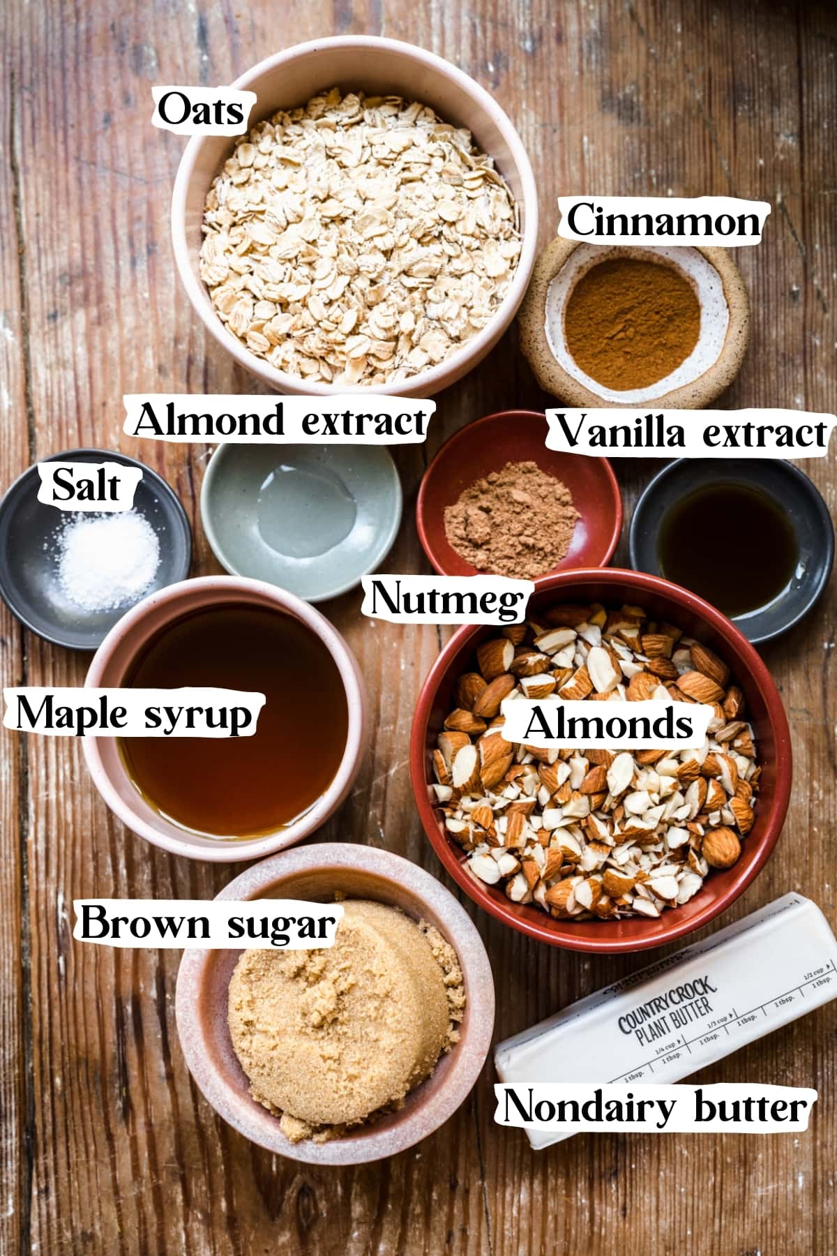 overhead view of ingredients for almond granola in small prep bowls. 