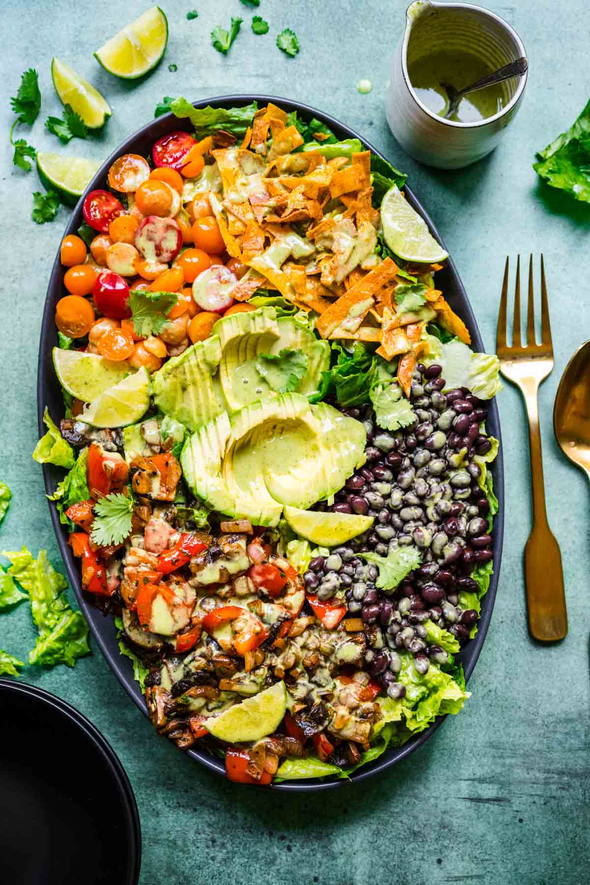 overhead view of fajita vegetable salad with black beans and avocado on a large platter.
