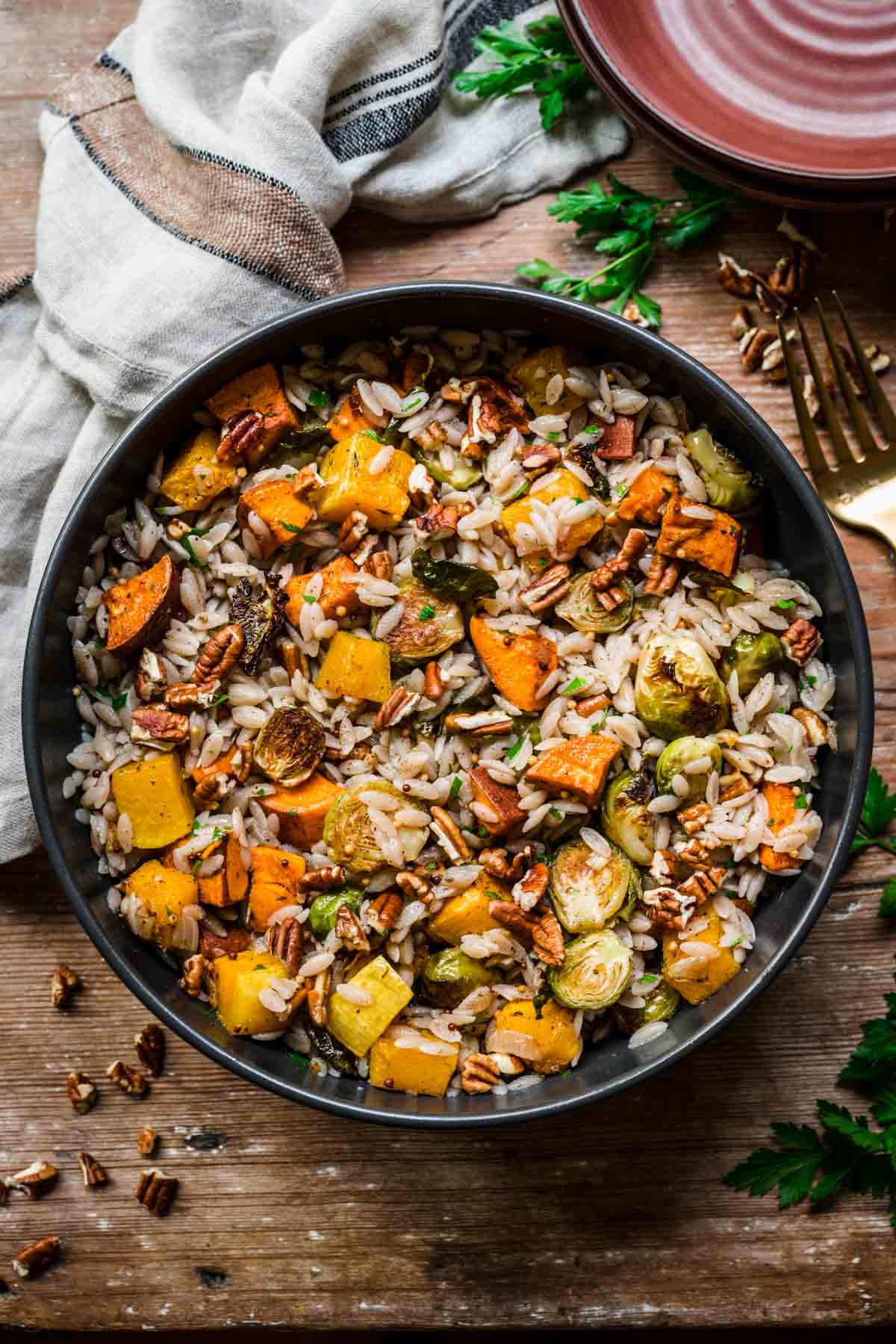 Overhead view of fall harvest salad with fall vegetables and pecans on top.