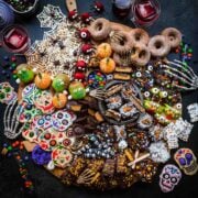 overhead view of halloween dessert charcuterie board with homemade halloween candy, donuts, spooky snacks and more.