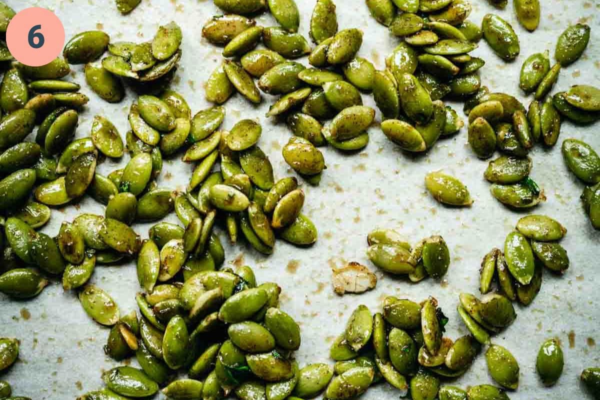 Close up of the roasted pepitas on parchment paper.