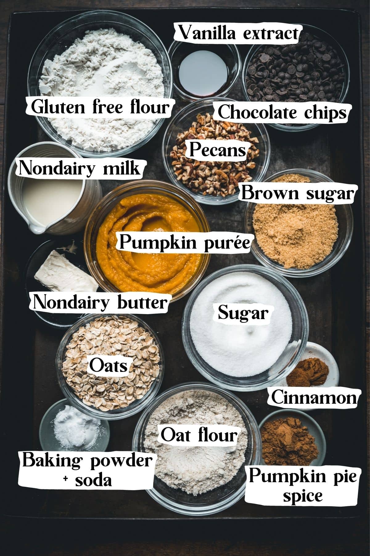 Overhead view of pumpkin muffin ingredients, including spices, flour, and chocolate chips.