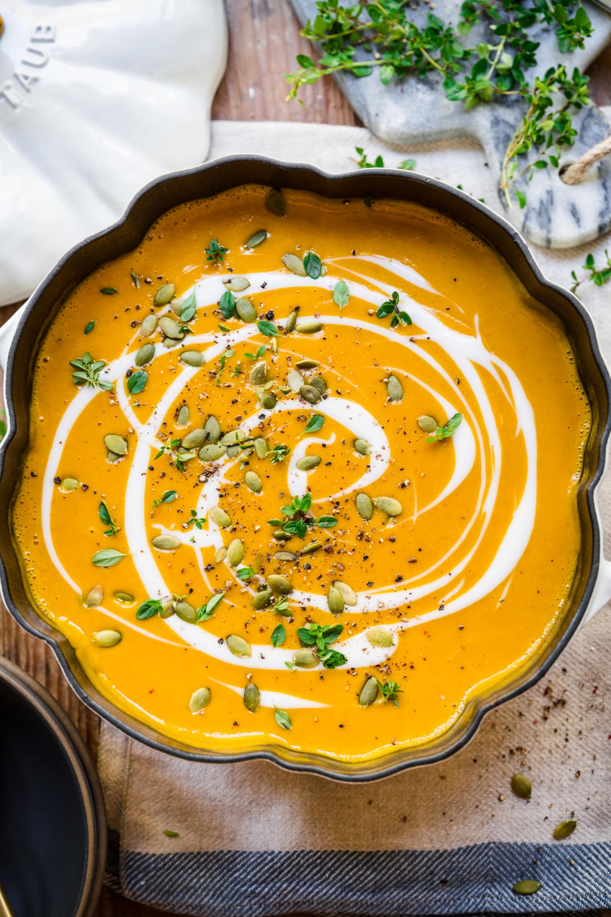 Overhead view of pumpkin soup in a big pumpkin shaped pot.